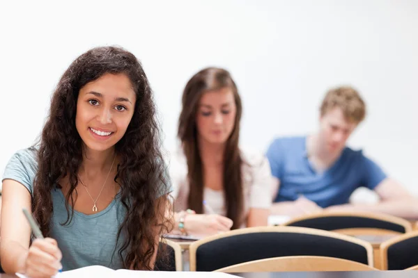 Uśmiechający się młodych studentów siedzi — Zdjęcie stockowe