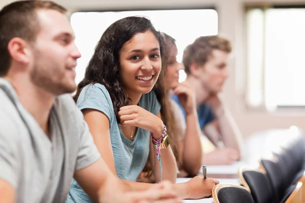 Estudiantes sonrientes escuchando a un profesor — Foto de Stock