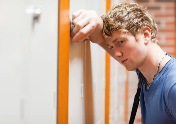 Close up of a lonely student leaning on a locker — Stock Photo, Image