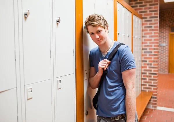 Student leunend op een locker — Stockfoto