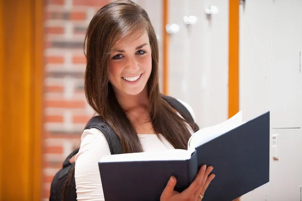 Estudante sorrindo segurando um livro — Fotografia de Stock