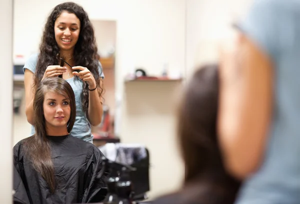 Mulher penteando o cabelo de um cliente — Fotografia de Stock