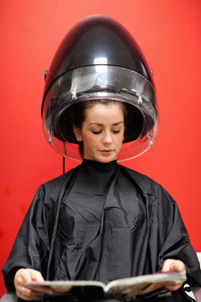 Retrato de uma mulher sob uma máquina de cabeleireiro — Fotografia de Stock