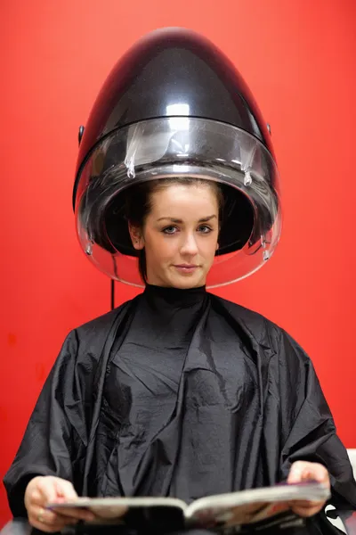 Retrato de uma jovem mulher sob uma máquina de cabeleireiro — Fotografia de Stock
