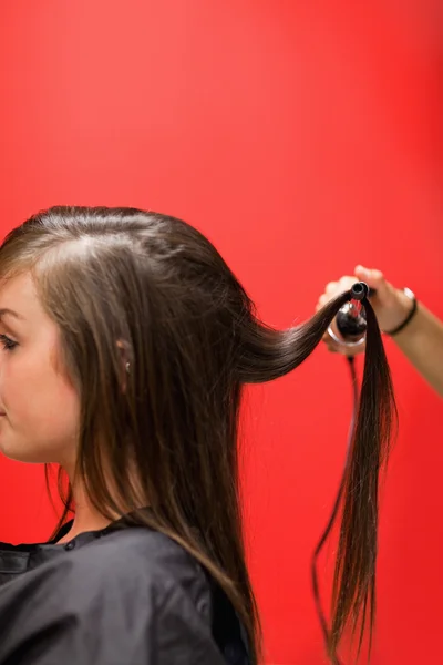 Portrait of a woman having her hair straightened — Stock Photo, Image