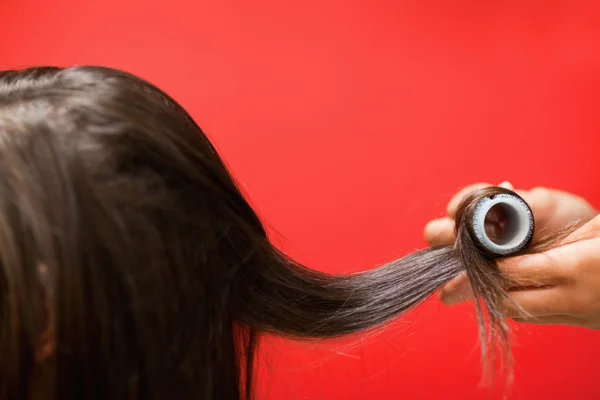 Close up of hands rolling hair — Stock Photo, Image