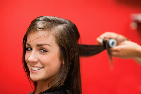 Smiling woman having her hair rolled — Stock Photo, Image