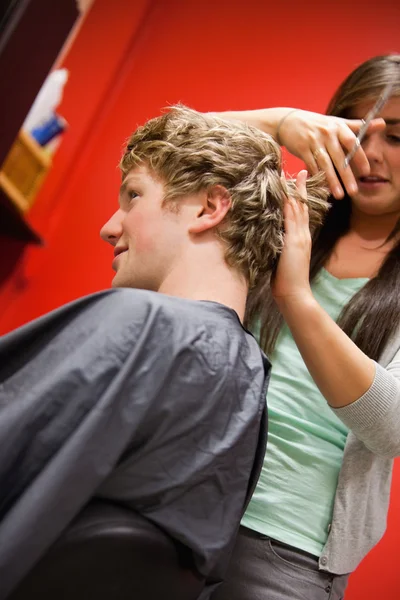 Retrato de uma mulher séria cortando o cabelo de um homem — Fotografia de Stock