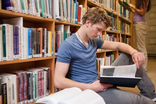 Estudante do sexo masculino lendo um livro — Fotografia de Stock