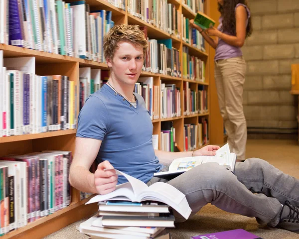 Hombre estudiante haciendo investigación mientras su compañero de clase está leyendo — Foto de Stock