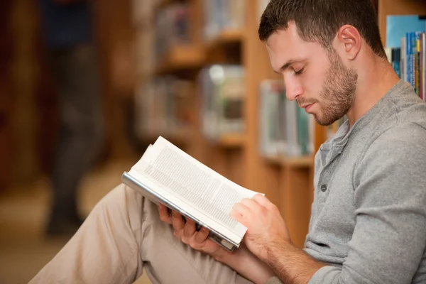 Grave studente di sesso maschile che legge un libro — Foto Stock