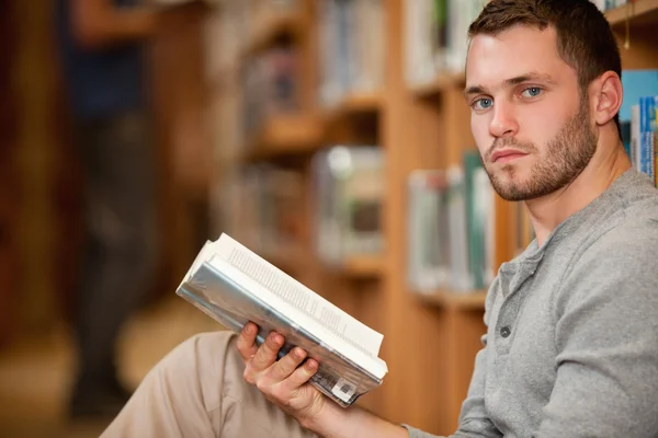 Estudante sério do sexo masculino segurando um livro — Fotografia de Stock