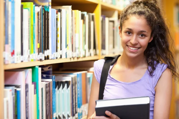 Sorridente studentessa in posa con un libro — Foto Stock
