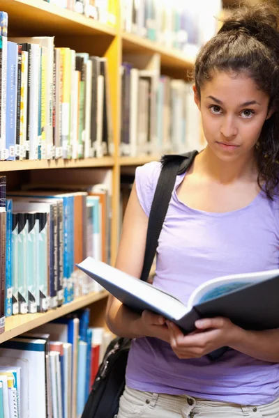 Портрет серьезной студентки с книгой в руках — стоковое фото