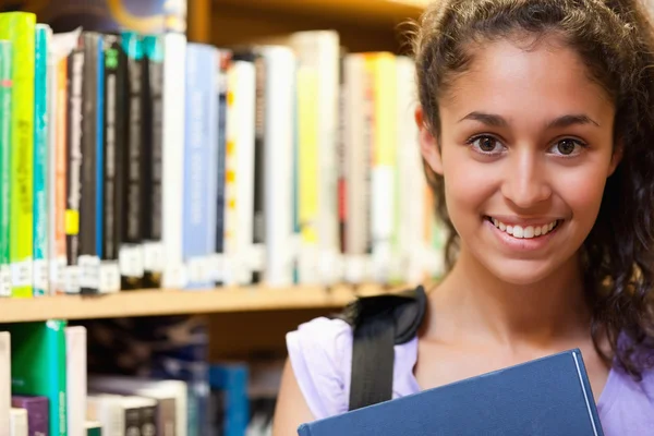 Mujer feliz estudiante sosteniendo un libro — Foto de Stock