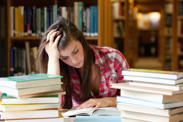 Estudante focado rodeado de livros — Fotografia de Stock