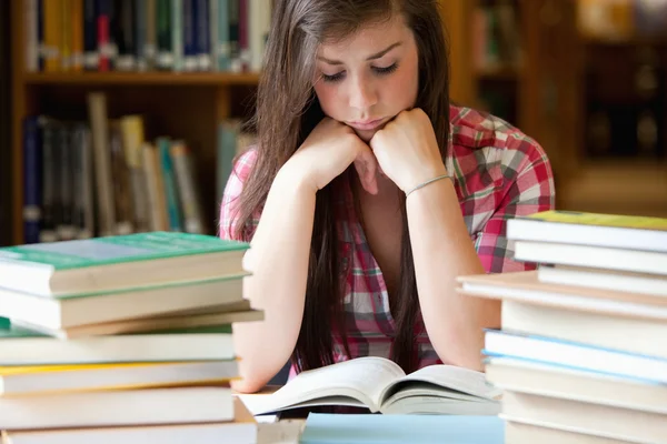 Mulher estudiosa rodeada de livros — Fotografia de Stock