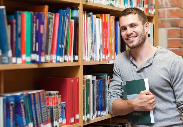 Усміхнений студент чоловічої статі тримає книгу — стокове фото