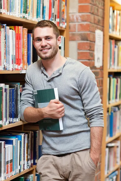 Retrato de um estudante do sexo masculino sorridente segurando um livro — Fotografia de Stock