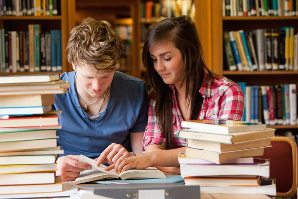 Seriöse Studenten schauen sich ein Buch an — Stockfoto