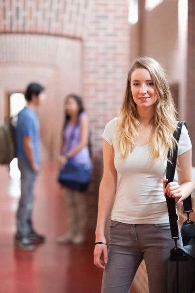 Portrait of a student posing while her friends are talking — Stock Photo, Image