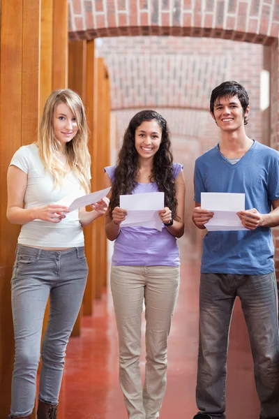 Retrato de estudiantes sonrientes sosteniendo un pedazo de papel — Foto de Stock