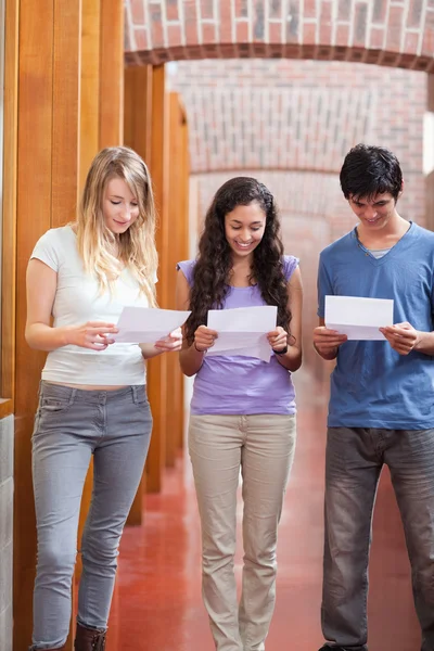 Portrait of students reading a piece of paper — Stock Photo, Image
