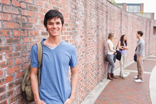 Manlig student poserar medan hans vänner talar — Stockfoto