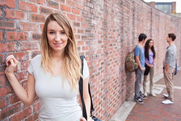 Vacker student poserar medan hennes vänner talar — Stockfoto