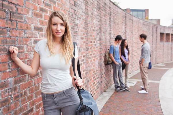 Söt student poserar medan hennes vänner talar — Stockfoto