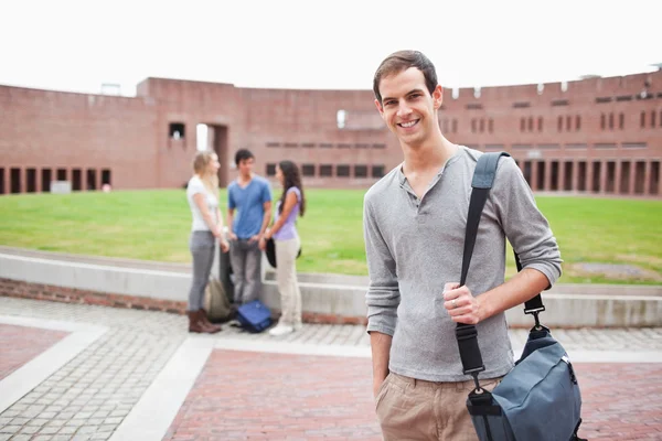 Student posing while his classmates are talking — Stock Photo, Image