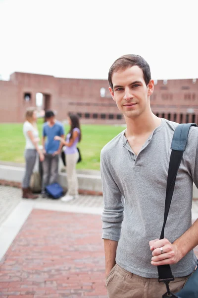 Portrait of a student posing while his classmates are talking — Stock Photo, Image