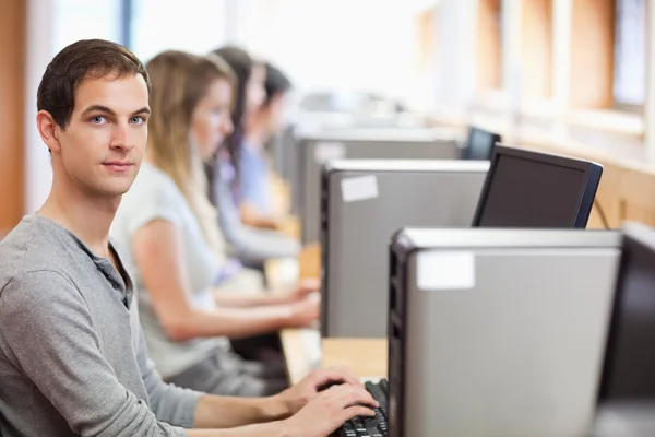 Estudiante masculino posando con una computadora — Foto de Stock