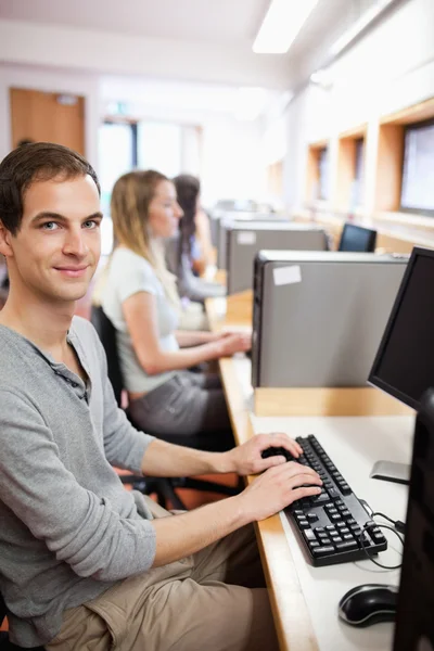 Portret van een jonge mannelijke student poseren met een computer — Stockfoto