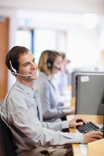 Portrait of a smiling customer assistant using a headset — Stok fotoğraf
