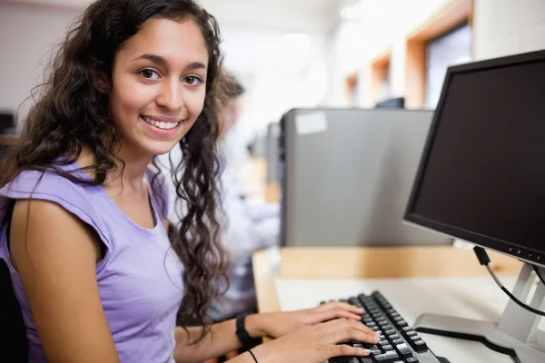 Mignon étudiant souriant avec un ordinateur — Photo