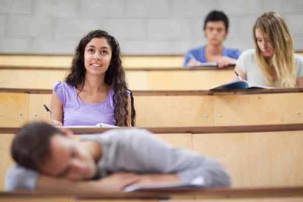 Студенты слушают, пока их одноклассник спит — стоковое фото