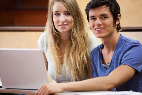 Jovens estudantes posando com um laptop — Fotografia de Stock