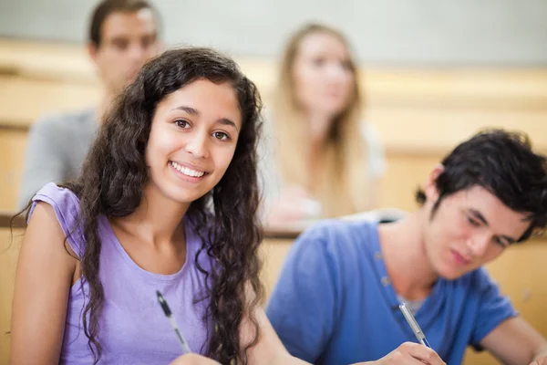 Estudante sorrindo tomando notas — Fotografia de Stock