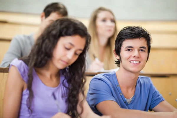 Studente essere distratto mentre i suoi compagni di classe sono in ascolto — Foto Stock