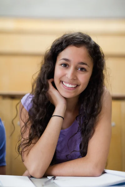 Portrét smějící se studenta, opírá se o její ruku — Stock fotografie