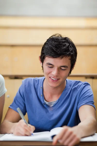 Retrato de un joven estudiante guapo tomando notas — Foto de Stock