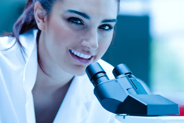 Jeune scientifique posant au microscope — Photo