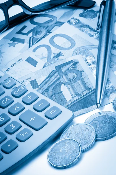 Dinheiro, moedas, caneta, óculos e calculadora de bolso — Fotografia de Stock