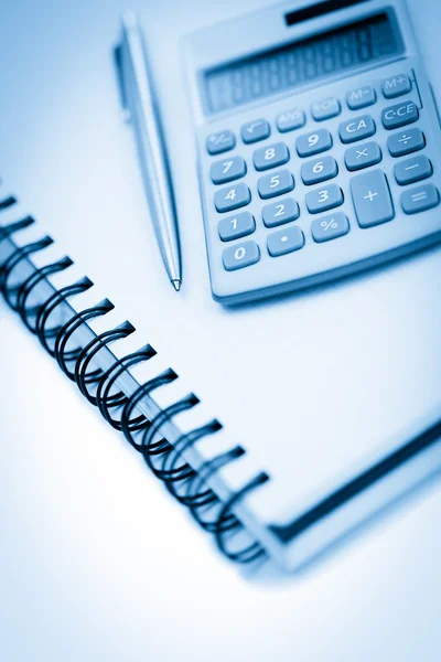 Cuaderno en ángulo con lápiz y calculadora de bolsillo — Foto de Stock