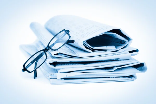 Újságok és a fekete szemüveg — Stock Fotó