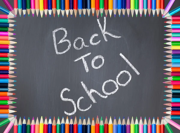 Volver a la escuela escrito en una pizarra enmarcada con lápiz de colores —  Fotos de Stock