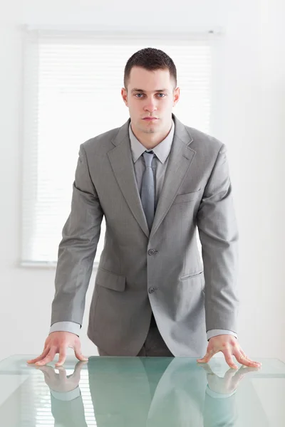 Uomo d'affari sicuro dietro un tavolo — Foto Stock
