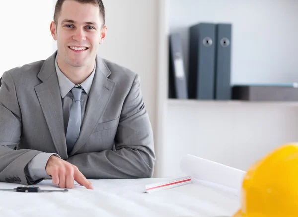 Smiling architect working on a building plan — Stock Photo, Image