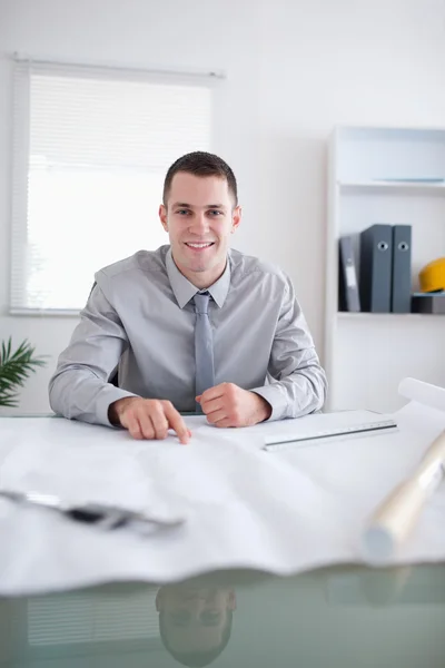 Close up of smiling architect working on a construction plan — Stock Photo, Image